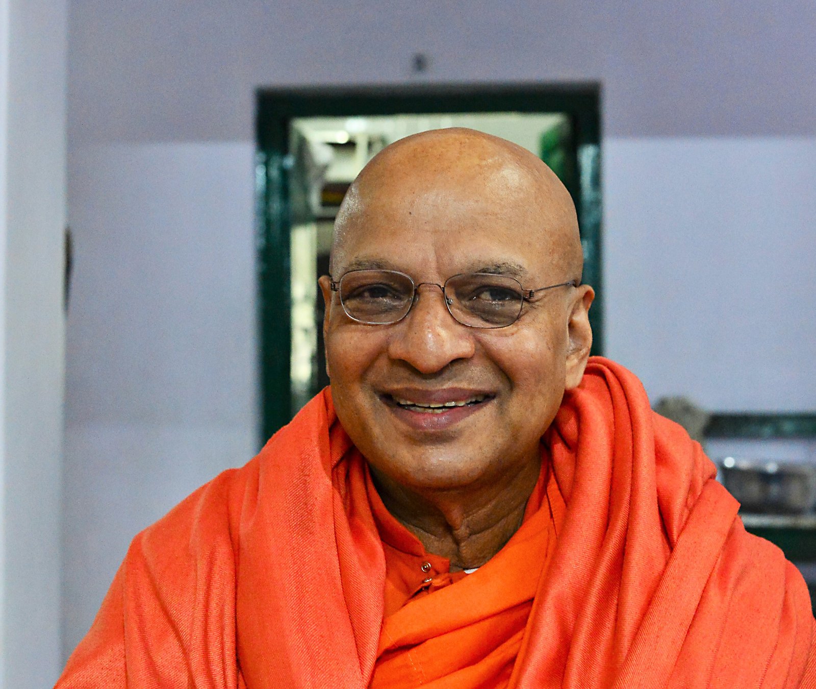 Chief Reverend K. Sri Dhammaratana smiling in his orange monastic robes
